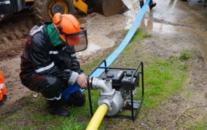 Persona utiliza una motobomba, implemento que será parte de los kits de emergencia para juntas de vecinos de Villa Alemana.