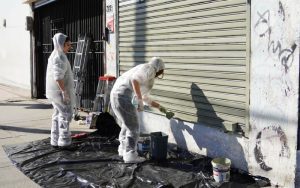 Voluntarios realizan labores de pintado en locales comerciales del centro de Villa Alemana.